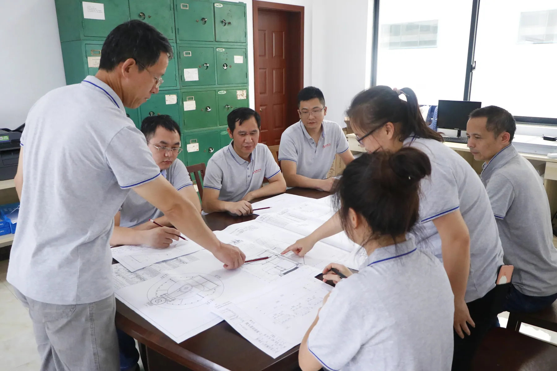 Cronus engineering team discussing powder processing equipment design